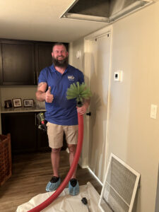 A Duct Dudes technician giving a thumbs up, holding a duct cleaning brush tool after a job in Scottsdale, AZ.