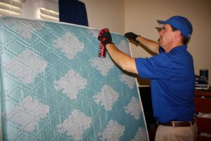 A Capital Pest Services technician treating a mattress for bed bugs in Raleigh, NC.