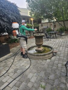 A Mosquito Joe of Columbia technician treating a patio area and fountain for mosquito and pest control in Columbia, SC.
