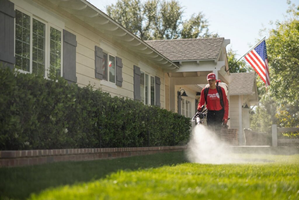 A Mosquito Shield technician treating a residential lawn for mosquito and pest control in Downtown Atlanta, GA.