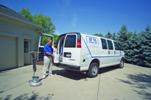 A Magna-Dry Carpet and Upholstery Cleaning technician unloading equipment from a branded van in Cincinnati, OH.