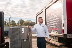 A technician unloading a new outdoor HVAC unit from a company truck at Parks Heating Cooling Plumbing & Electrical in Indian Trail, NC