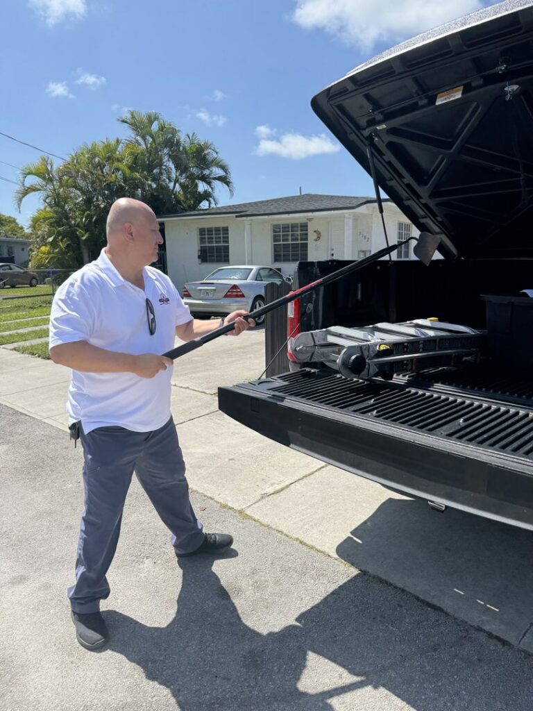 A technician unloading pest control equipment from a truck for PNP Pest Solutions LLC in Miami, FL.
