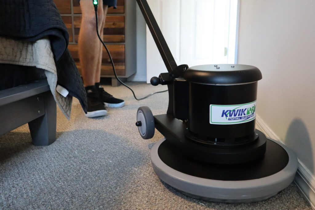 A technician from Rhode Island Kwik Dry using a professional carpet cleaning machine in a bedroom in Rhode Island.