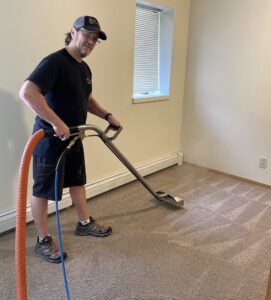 A technician using a carpet cleaning wand to clean carpet, creating patterns by Alaska Floor Care Specialists in Fairbanks, AK.