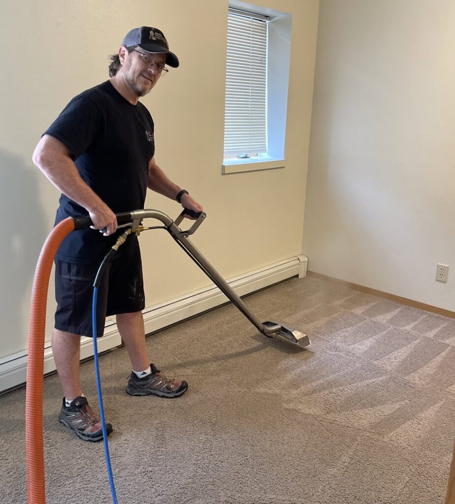 A technician using a carpet cleaning wand to clean carpet, creating patterns by Alaska Floor Care Specialists in Fairbanks, AK.