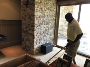 A technician from Johns Creek Carpet Cleaner using a carpet extractor on a living room carpet in Johns Creek, GA.