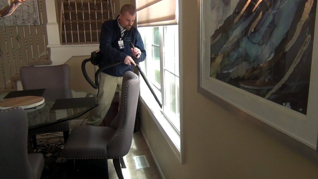 A technician vacuuming inside a home for pest control services by Springer Professional Home Services in Des Moines, IA.