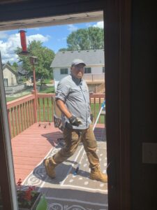 A pest control technician walking onto a residential deck after completing a service for Pest Free Rochester in Rochester, MN.