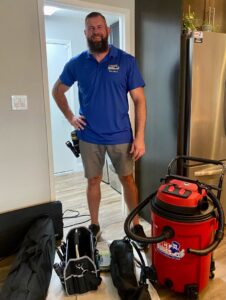 A Duct Dudes technician standing with a red Rotobrush vacuum and tools, ready for a job in Scottsdale, AZ.