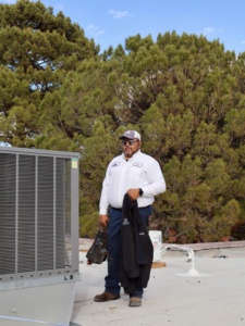 An Ignitify Commercial Grade HVAC technician with tools next to a rooftop HVAC unit in El Paso, TX.