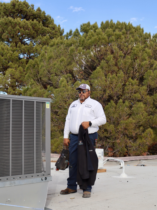 An Ignitify Commercial Grade HVAC technician with tools next to a rooftop HVAC unit in El Paso, TX.