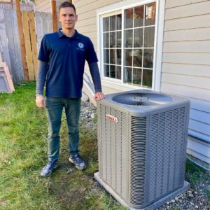 A Mr. Fridge technician standing next to a newly installed Lennox outdoor HVAC unit in Seattle, WA.