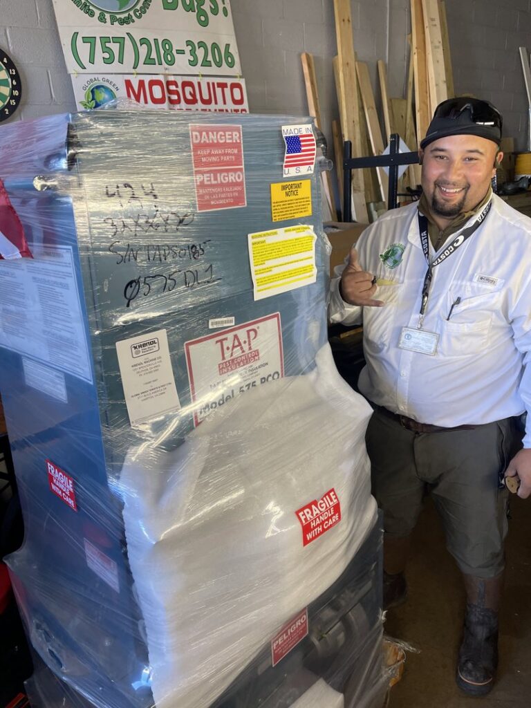 A Global Green Termite & Pest Control LLC technician in Hampton, VA, standing next to pest control equipment, ready for a job.
