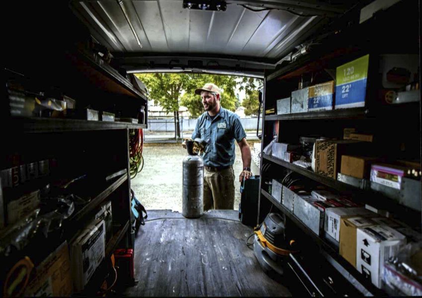 A Gagles Heating technician with a refrigerant tank in a service van in Salem, OR.