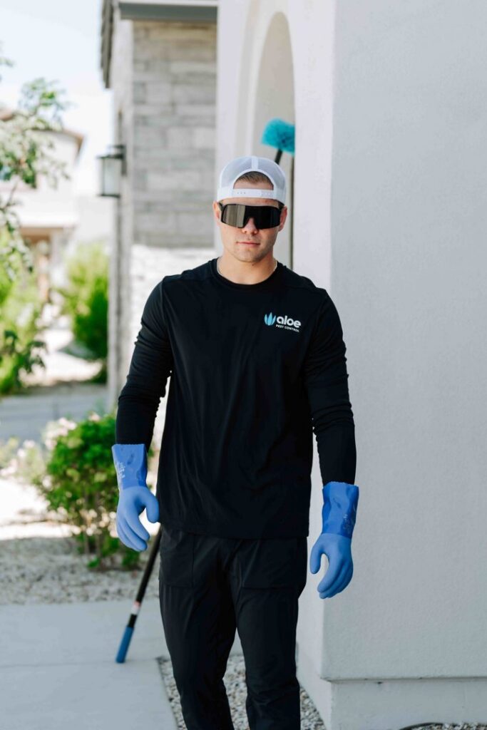A pest control technician from Aloe Pest Control carrying a web duster for service in Mesa, AZ.