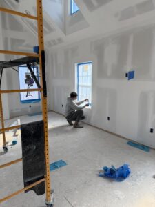 A technician working on a duct connection near a furnace for Green Seal Energy in Overland Park, KS.