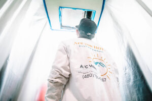 A technician working on ceiling ductwork or a vent, with the area protected, for A/C Valley, LLC in Tempe, AZ.