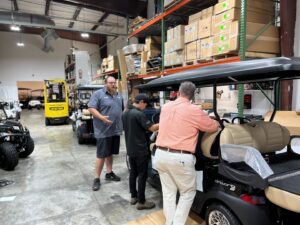 A Cart Electric technician performing maintenance on the interior of an electric golf cart in Nashville, TN.