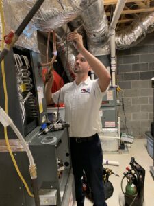 A technician working on a furnace or air handler with a torch for Pipe Wrench Plumbing, Heating & Cooling, Inc in Knoxville, TN.