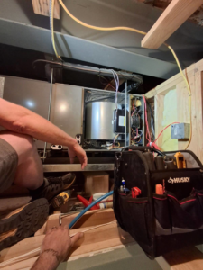 A technician performing maintenance on a furnace unit at JL Mechanical in Pleasant Grove, UT.