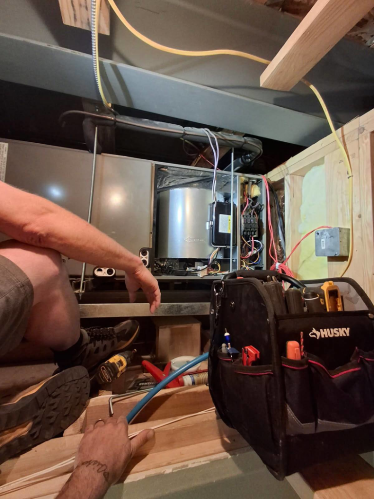A technician performing maintenance on a furnace unit at JL Mechanical in Pleasant Grove, UT.