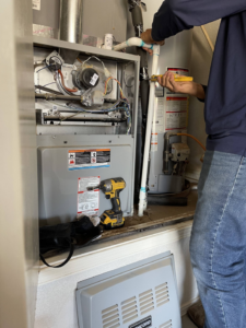 A technician performing maintenance on a furnace unit for Lone Star Mechanical in El Paso, TX.