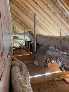 A U.S. HVAC Services, LLC technician working on an outdoor HVAC unit next to a brick wall in Madison, AL.