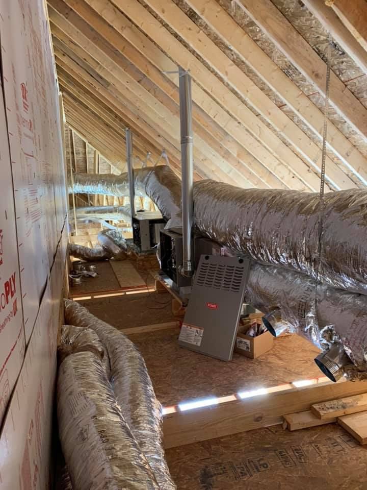 A U.S. HVAC Services, LLC technician working on an outdoor HVAC unit next to a brick wall in Madison, AL.