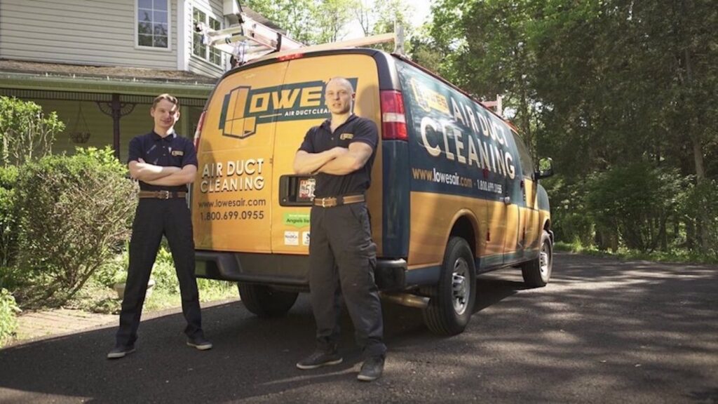 A technician using a drill while working on an HVAC unit and ductwork for Lowe's Air Duct Cleaning in Fairlawn, OH.