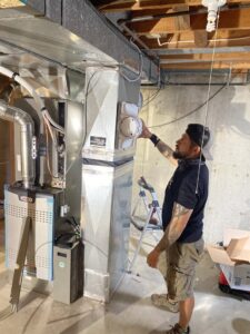 A True Heating and Cooling technician working on an indoor furnace and ductwork in Northeast Westminster, CO.