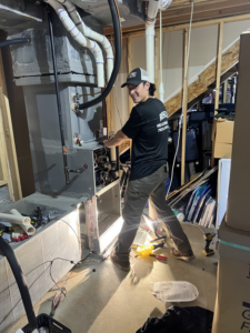 A technician working on an indoor HVAC unit for Rescue Heating and Air Conditioning in Manassas, VA