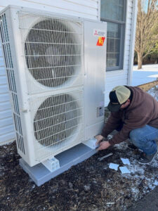 A Tapper Energy technician working on a Mitsubishi outdoor heat pump unit in Dauphin, PA.