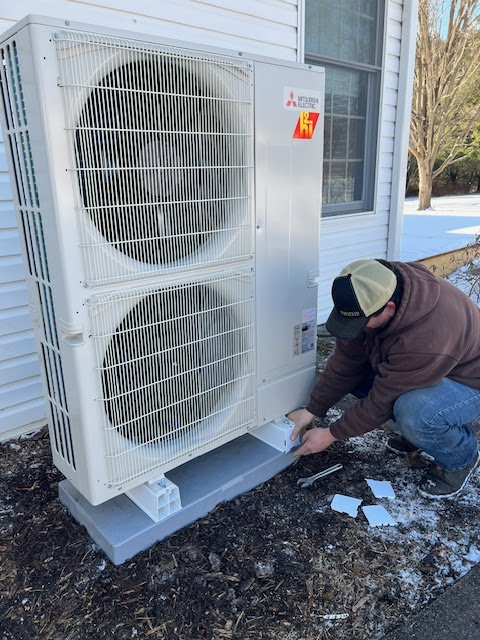 A Tapper Energy technician working on a Mitsubishi outdoor heat pump unit in Dauphin, PA.