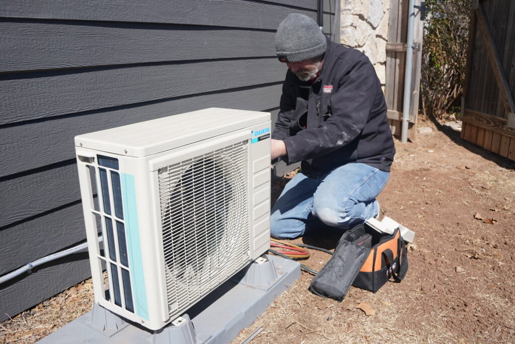 A technician working on an outdoor AC unit for Call The Doc Air Doctor Heating, Air Conditioning and Plumbing in Richardson, TX.