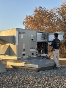 An Hvac Buddies technician performing maintenance on a commercial rooftop HVAC unit in Chicago, IL