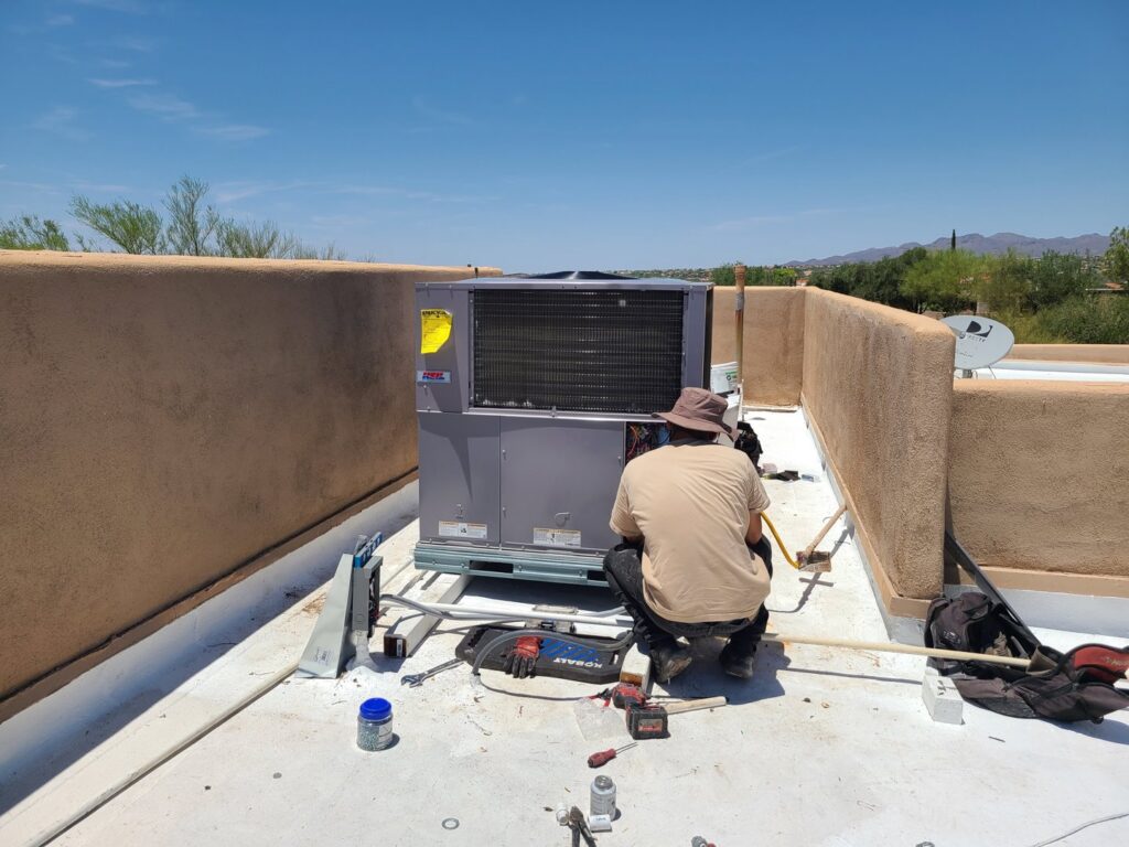 A technician performing maintenance or repair on a rooftop HVAC unit for Heating & Air Paramedics - Tucson in Tucson, AZ.