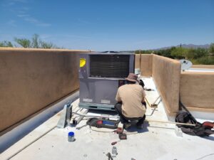 A technician performing maintenance or repair on a rooftop HVAC unit for Heating & Air Paramedics - Tucson in Tucson, AZ.