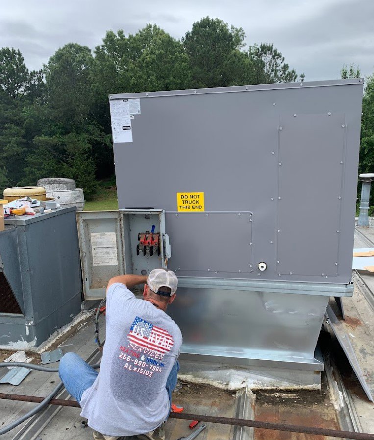 A U.S. HVAC Services technician working on a commercial rooftop HVAC unit in Madison, AL.
