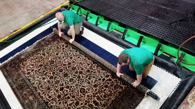 Two Chem-Dry technicians professionally cleaning a large area rug at Chem-Dry of Seattle in Seattle, WA