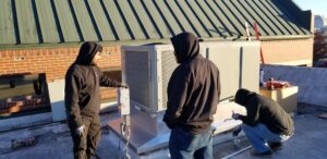 Technicians inspecting a commercial rooftop HVAC unit for Frederick Plumbing, Heating & Air Conditioning in Wichita, KS