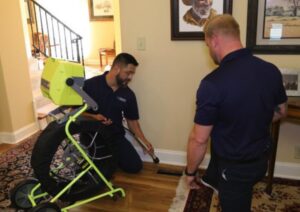 Two Air Doctor Duct Cleaning & Lining technicians inspecting a floor vent with specialized camera equipment in a home in Tulsa, OK.