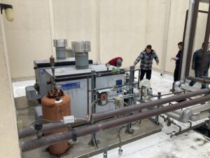 Technicians inspecting large industrial HVAC units on a rooftop for Hurn Mechanical Heating & Cooling in El Cajon, CA.
