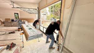 Two technicians from Iconic Garage Door Service installing a new garage door in a residential construction project in Queen Creek, AZ