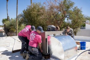 HVAC technicians from AZ Perfect Comfort installing a rooftop air conditioning unit on a home in Phoenix, AZ.