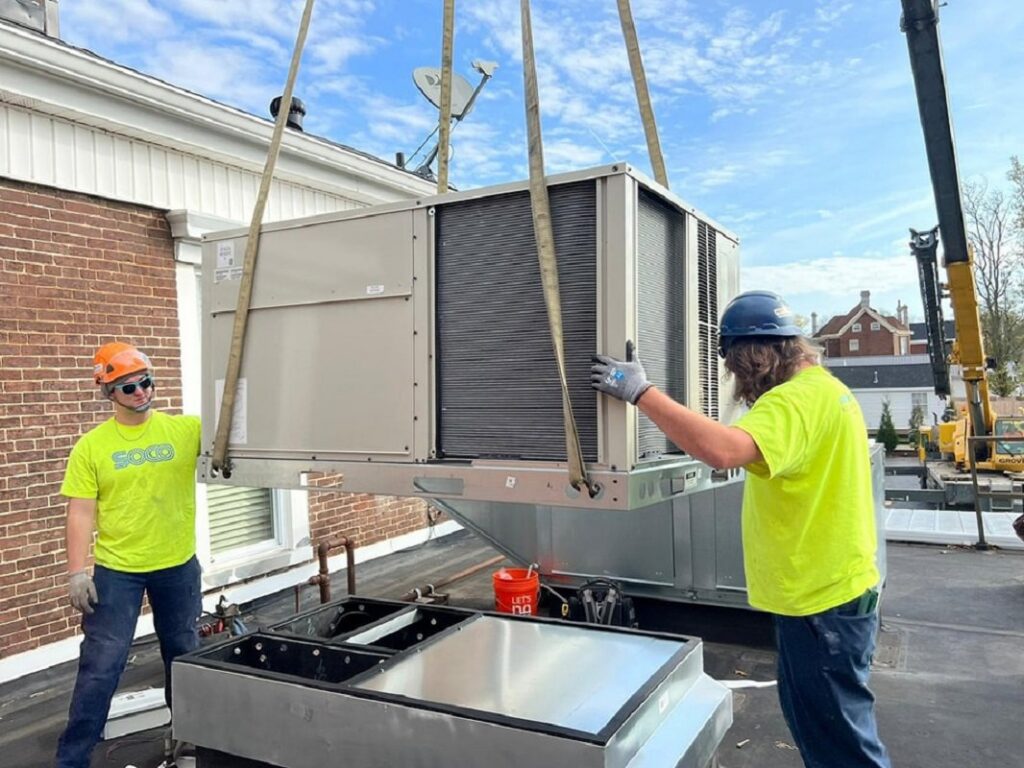 Technicians installing a large rooftop HVAC unit for Southern Comfort Heating & Cooling in Lexington, KY