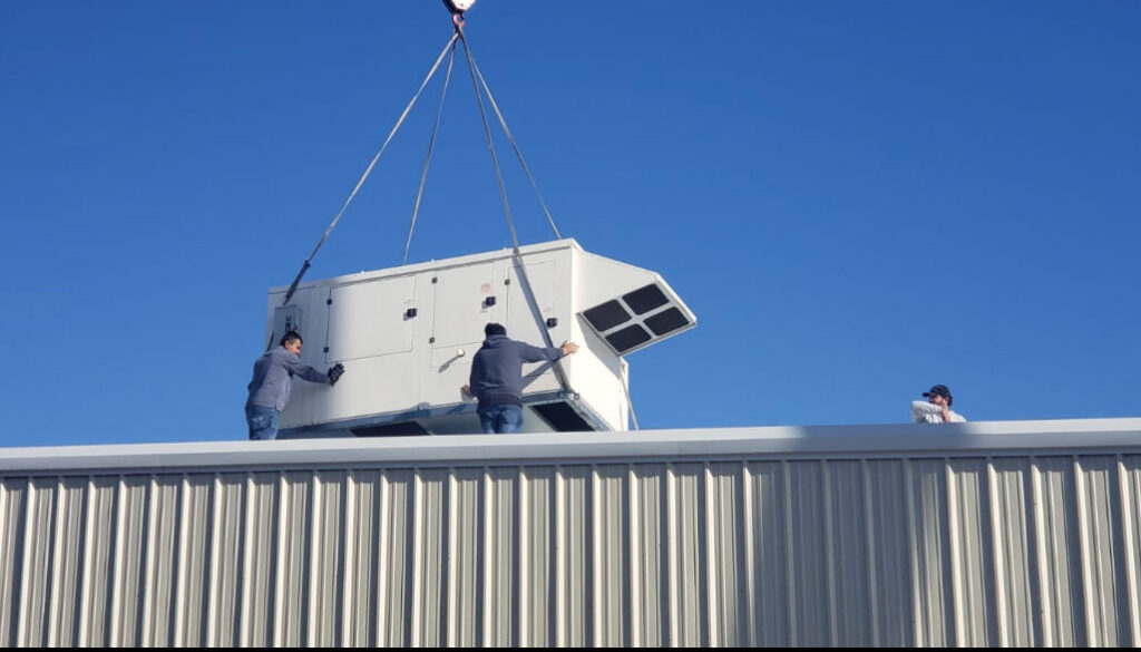 Tornado Heating and Air technicians installing a large rooftop HVAC unit in Tulsa, OK.