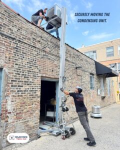 Empire Tech, Inc. technicians securely moving an HVAC condensing unit for installation in Schaumburg, IL.