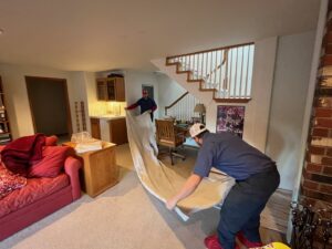 Technicians from ACI Northwest Heating, Cooling & Electrical preparing a residential work area by laying down protective coverings in Dalton Gardens, ID.