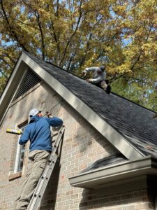 Two technicians repairing a roof for wildlife exclusion at a home by Evictus Wildlife Solutions in South Bend, IN.
